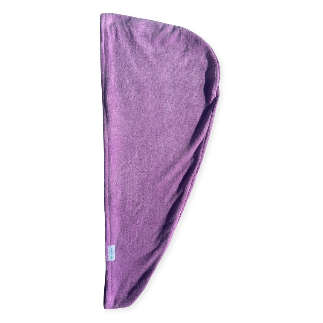 A purple microfiber hair dryer wrap towel, folded into a teardrop shape, shown against a plain white background.